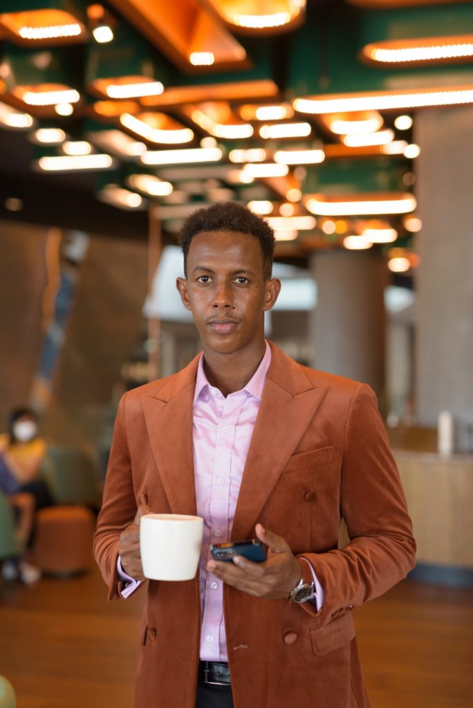 Portrait of handsome black African businessman in coffee shop